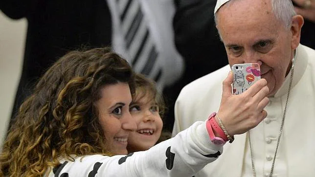 El Papa Francisco (dcha) posa para una foto con dos fieles en la audiencia del pasado miércoles