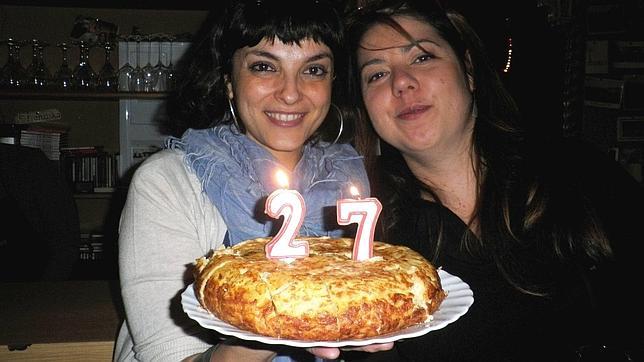 Elena, a la izquierda, sujeta la tortilla hecha por Peter para celebrar su cumpleaños