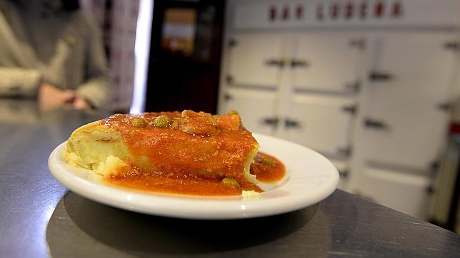 La tortilla de patata del bar Ludeña, cubierta con la salsa de la carcamusa