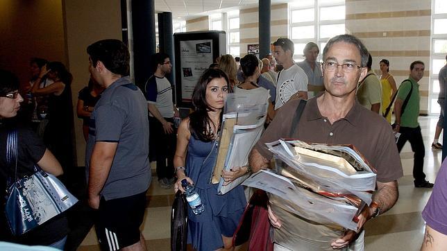 Un hombre y una mujer portan exámenes y documentación.