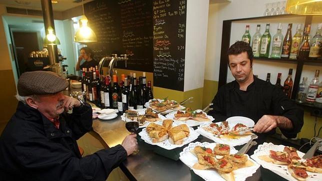 Un paisano se toma un vino acompañado de los famosos pintxos de tortilla del Txirimiri
