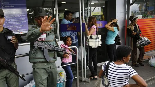 La Guardia Nacional venezolana vigila la entrada de un supermercado de Caracas