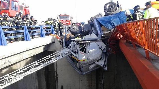 Un espectacular accidente deja a un camionero colgado de un puente a 9 metros de altura