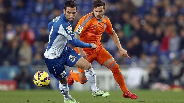 El defensa del Español Arbilla (i) disputa un balón a Piatti, delantero del Valencia