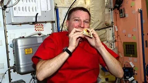 El astronauta, dando buena cuenta de su cena