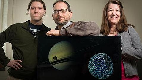 Los investigadores, con una imagen de Titán delante de Saturno y la teórica membrana celular