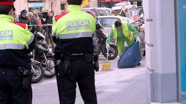 Dos mossos hacen guardia en el lugar de un crimen, en Barcelona