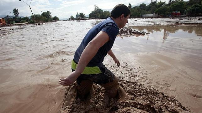 Un hombre cruza una zona inundada este jueves en la localidad de Paipote a 10 km de Copiapo