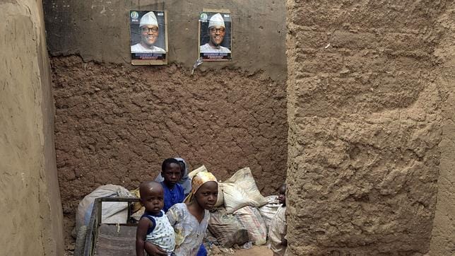 Un grupo de niños juega bajo carteles con el rostro del candidato Buhari en Daura, Nigeria