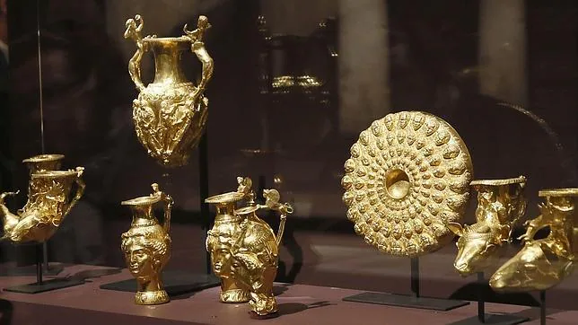 Una mujer observa piezas de oro tracias expuestas en el Louvre