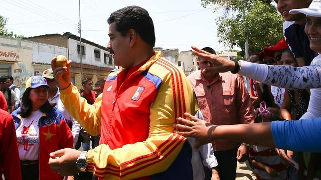 Nicolás Maduro, muestra el mango que le acaban de lanzar, durante un acto político en Aragua