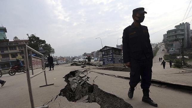 Un soldado camina junto a una grieta en el suelo en Katmandú