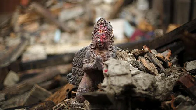 Una estatua religiosa entre los restos de varios edificios en Nepal