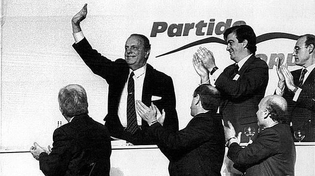 Álvarez Cascos aplaude a Manuel Fraga en el X Congreso del PP, celebrado en Sevilla, en el que Aznar asumió el liderazgo. A sus espaldas, el primer logo del partido, diseñado por Fernando Martínez Vidal
