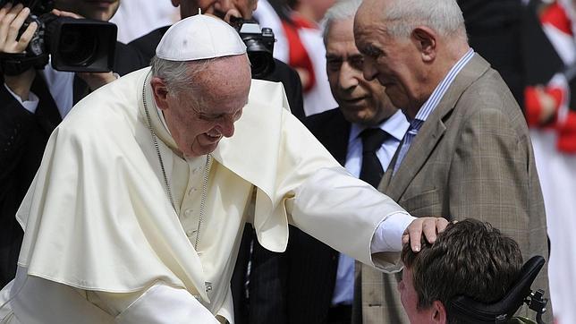 El Papa Francisco saluda a una mujer en silla de ruedas a su llegada a la audiencia general celebrada en el vaticano