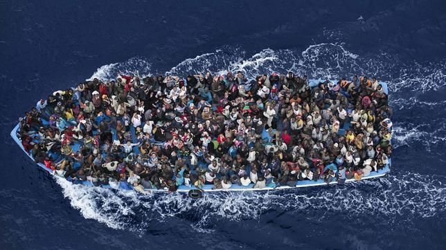 Inmigrantes en una patera, antes de ser rescatados por una fragata italiana