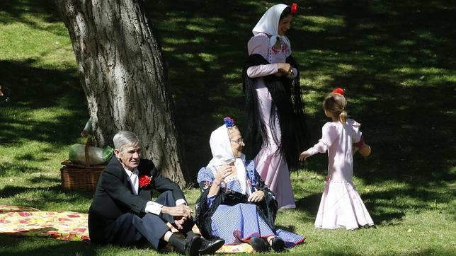 Una familia de chulapos disfruta de la tarde en la Pradera de San Isidro