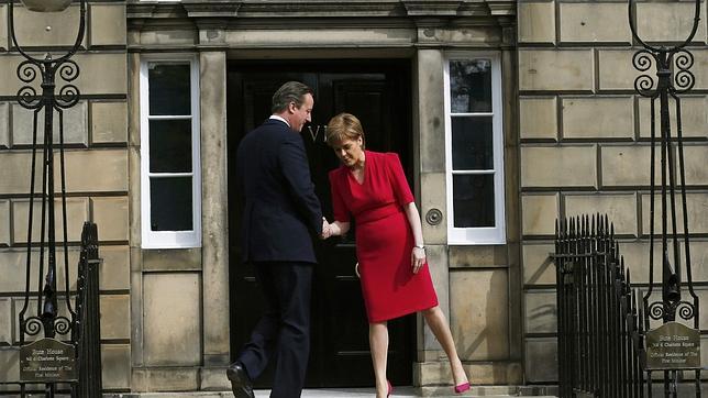 La primera ministra escocesa, Sturgeon, saluda al primer ministro británico, Cameron, en Edimburgo
