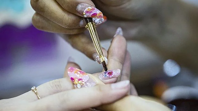 Un trabajador arregla las uñas de una mujer en Tokio