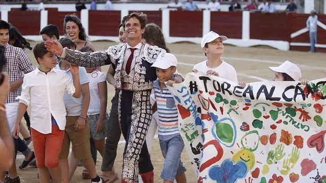 El Juli, rodeado de niños que portan la pancarta «Torea al cáncer»