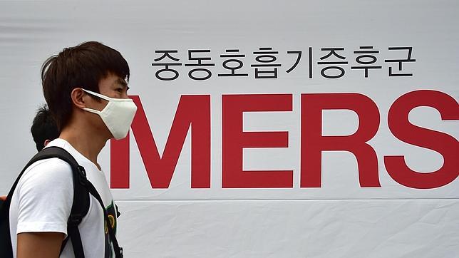 Un hombre camina en Seúl (Corea del Sur), protegido por una mascarilla