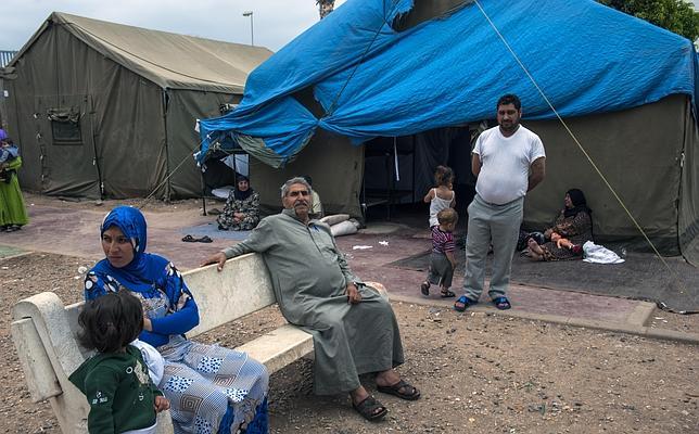 Familias de refugiados sirios ante las tiendas en las que viven en el CETI de Melilla