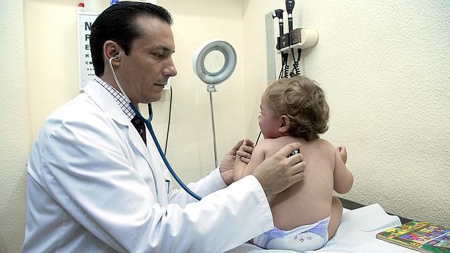 Imagen de archivo de un médico auscultando a un bebé
