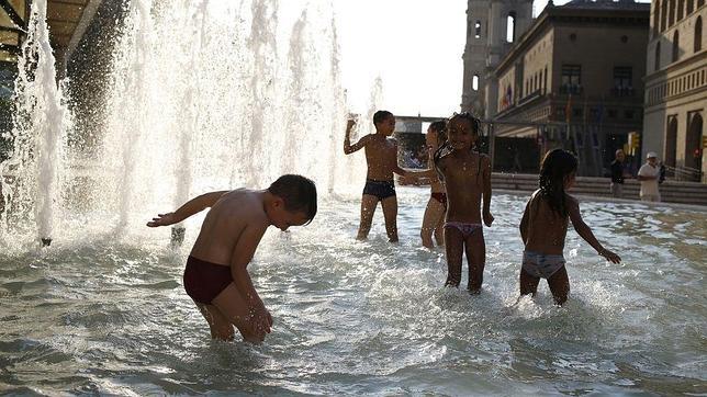 Niños bañándose en una fuente de la Plaza del Pilar de Zaragoza