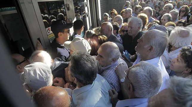 Una multitud de pensionistas hace cola ante una sucursal para poder retirar parte de sus pensiones en Atenas