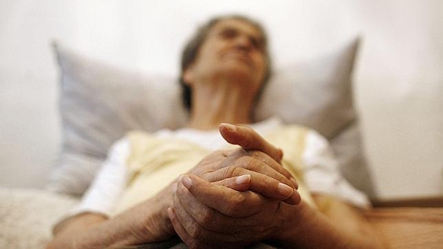 Una mujer afectada por el Alzheimer descansa recostada en la cama