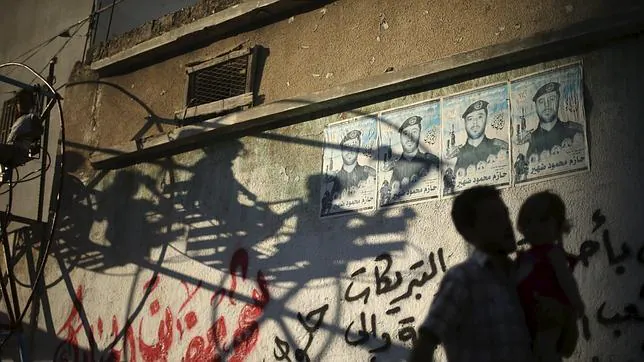 Un hombre camina junto a su hijo en Gaza