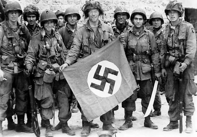 Varios miembros de la 101ª División Aerotransportada sujetan una bandera nazi robada