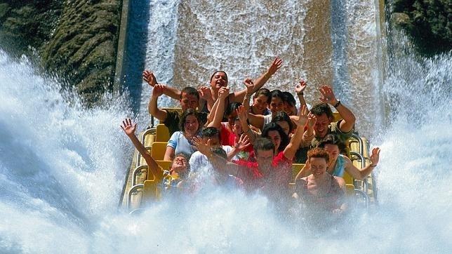 Varios jóvenes disfrutan de un tobogán en un parque acuático