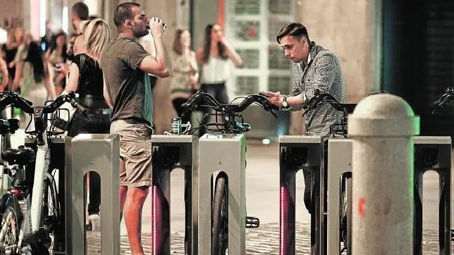 Dos jóvenes a punto de coger las bicis tras haber consumido alcohol en plena Puerta del Sol