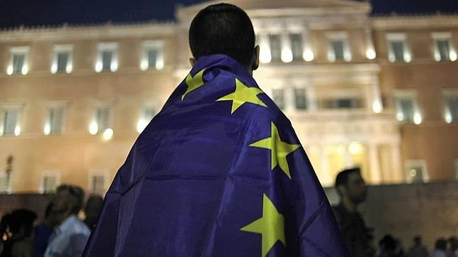Un manifestante se cubre con una bandera de la Unión Europea durante una manifestación a favor de la zona euro frente al Parlamento griego