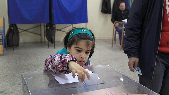 Una niña ayuda a su padre a votar en las últimas elecciones