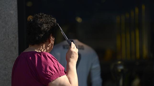 Una mujer se protege de la radiación solar con ayuda de su abanico