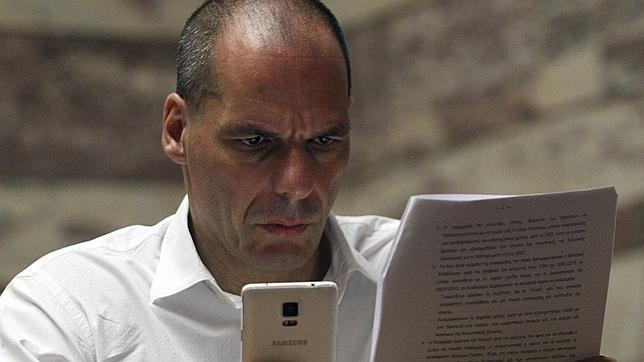 El exministro de Finanzas griego Yanis Varufakis lee el documento de la propuesta griega durante una reunión del grupo parlamentario de Zyriza en el Parlamento