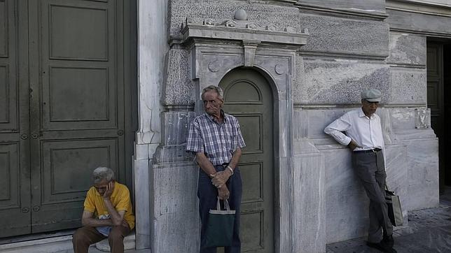Pensionistas esperan para cobrar a las afueras de una sucursal del Banco Nacional de Grecia en Atenas