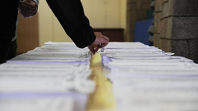 Un hombre escogiendo su papeleta durante una jornada electoral
