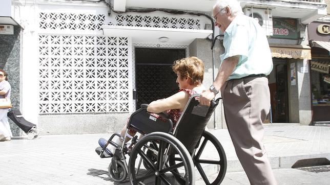 Un señor lleva a su mujer en silla de ruedas