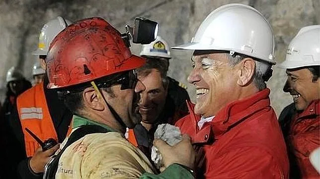 El expresidente chileno Sebastián Piñera abraza al minero Mario Sepúlveda al pie de la mina