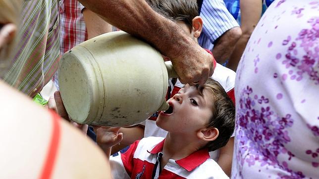 Un niño toledano bebe de los botijos del agua de la Virgen del Sagrario