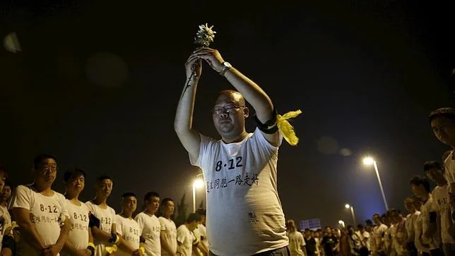 Un hombre durante el homenaje a las víctimas de Tianjin