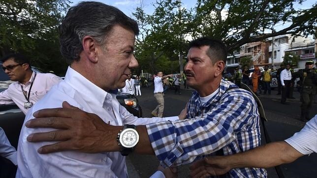 El presidente colombiano, Juan Manuel Santos esaluda a un hombre durante una visita a un refugio en Cúcuta, Colombia