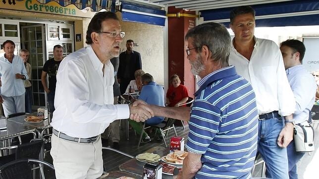 El presidente Mariano Rajoy y el candidato Xavier García Albiol se saludan a ciudadanos en Badalon