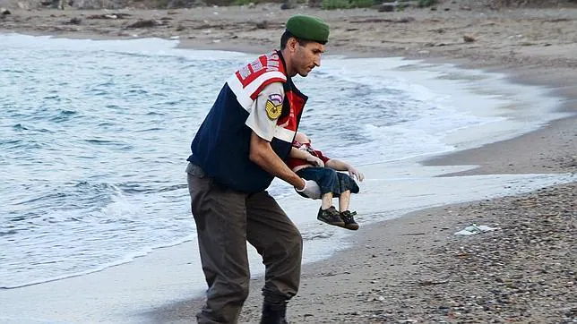 Un gendarme turco recupera el cadáver de un niño sirio ahogado al intentar alcanzar la costa griega de Kos