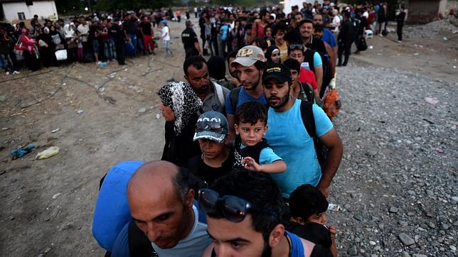 Emigrantes sirios esperan la autorización para abordar un tren y cruzar la frontera entre Macedonia y Grecia