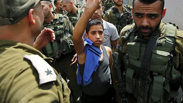 Un joven palestino es detenido por policías israelíes por lanzar piedras a soldados que patrullaban en Halhul, cerca de la ciudad cisjordana de Hebrón