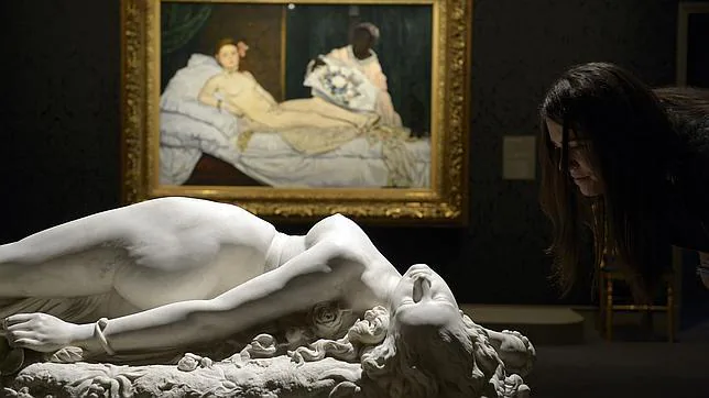 En primer plano, una escultura. Al fondo, la célebre «Olimpia», de Manet